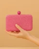 Bolso clutch de rafia fucsia con cierre de bola