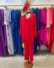 Conjunto rojo de pantalon y blusa con plumas