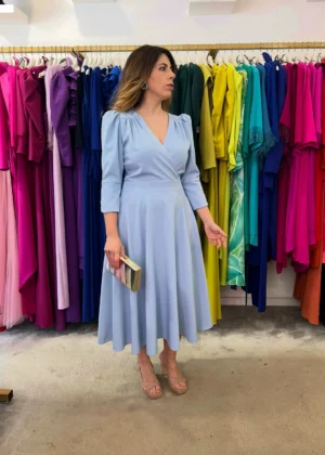 Vestido midi azul claro con escote cruzado y manga tres cuartos, ideal para eventos de día